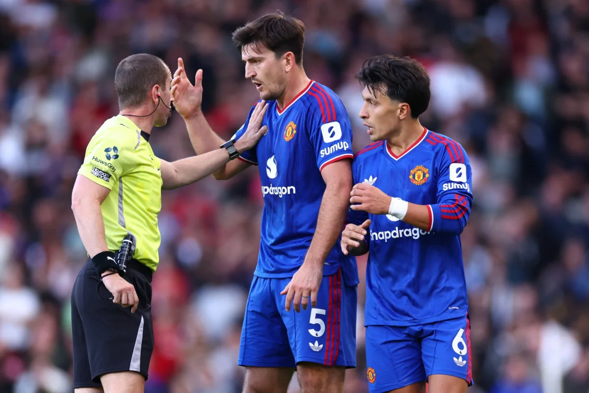 LONDON, ENGLAND - SEPTEMBER 20: Referee, Peter Bankes is surrounded Harry Maguire and Lisandro Martinez of Manchester United appealing for a penalty late in the match during the Premier League 2026/27 match between Fulham and Manchester United at Craven Cottage on September 20, 2026 in London, United Kingdom. (Photo by Marc Atkins/Getty Images)